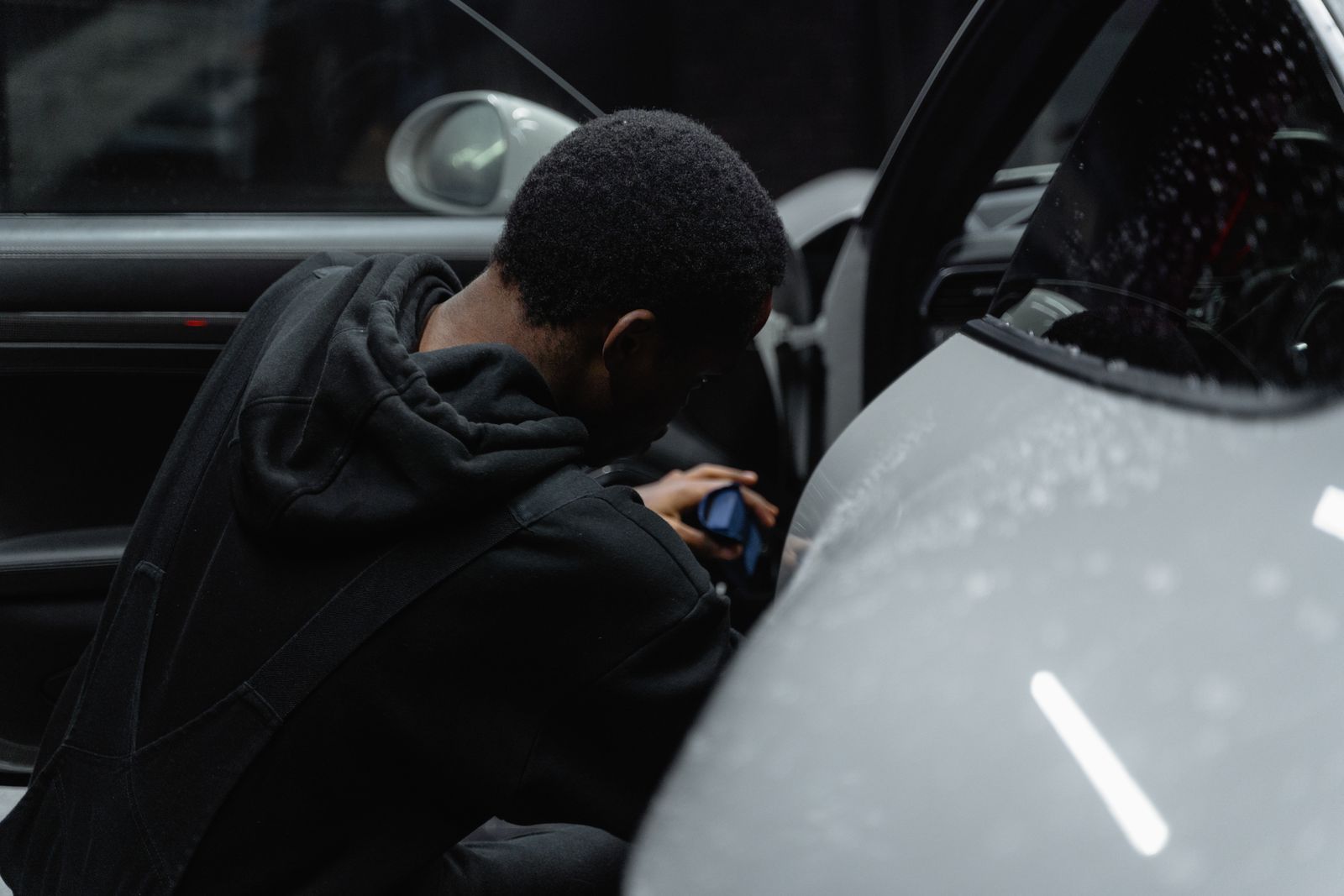 Detailer cleaning a car interior by hand